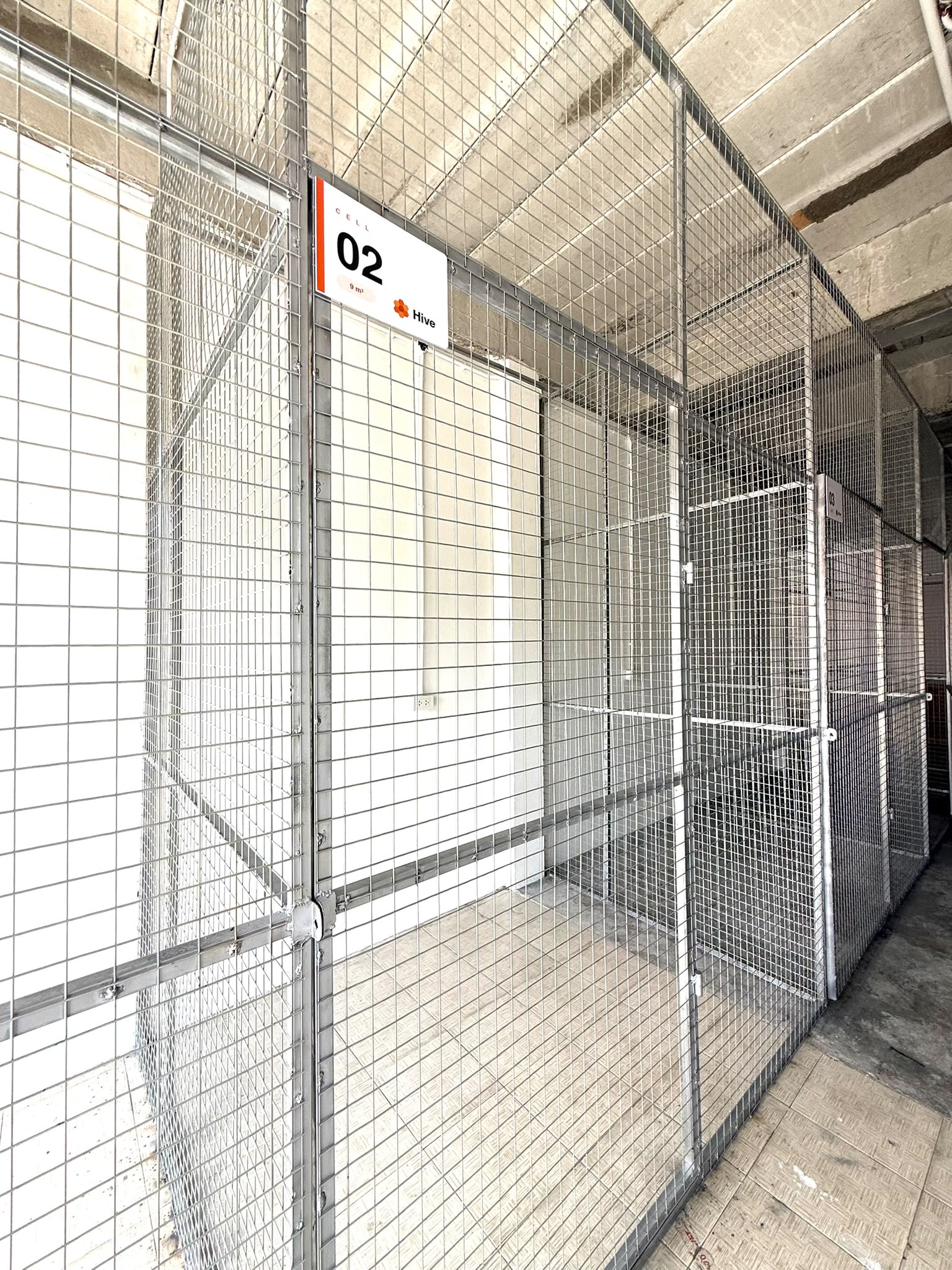 Aisle view of mesh storage units with branded cell signage