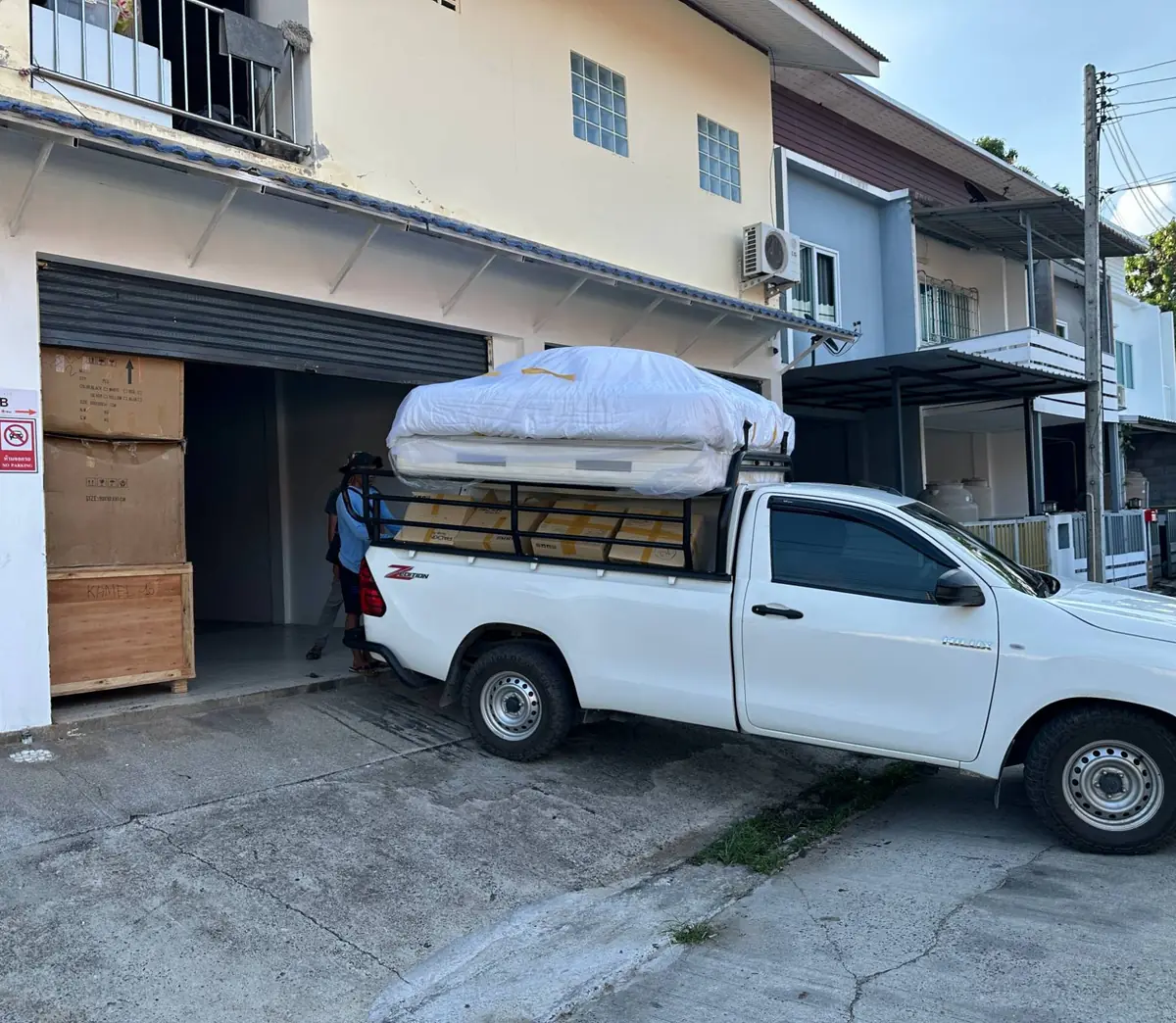 A Hive crew member walking into a storage unit beside the loaded pickup truck