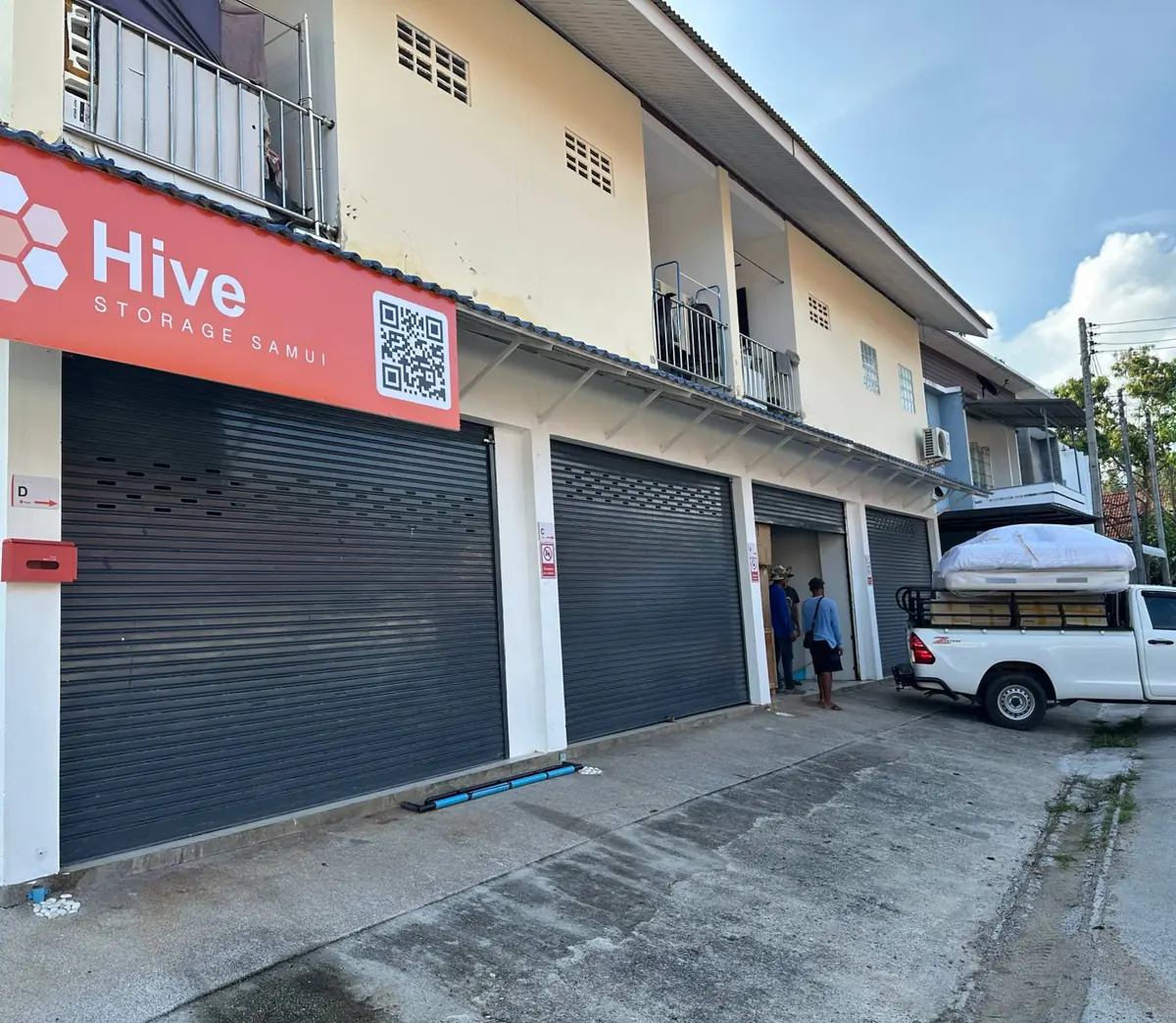 A Hive Storage Samui crew unloading a pickup truck outside the branded depot in Bophut