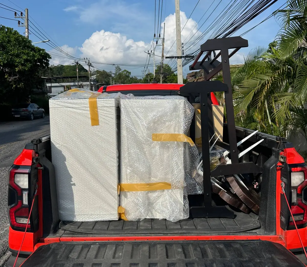 Furniture wrapped in bubble wrap and loaded into the bed of a second Hive pickup truck